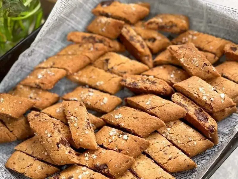 En hög med gyllene kolakakor med chokladbitar och flingsalt. Perfekt för ett enkelt kolakakor recept.