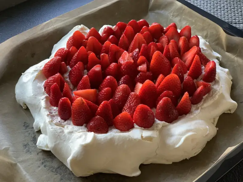 En stor pavlova i långpanna, täckt med vispgrädde och massor av färska jordgubbar. Perfekt för sommarens firanden!